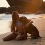 A woman and her dog enjoying a warm sunset together on Unawatuna Beach, Sri Lanka.